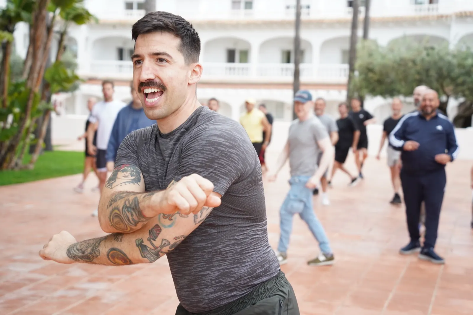 Sergio Toyos dando una clase de baile al aire libre, con el grupo siguiéndole detrás